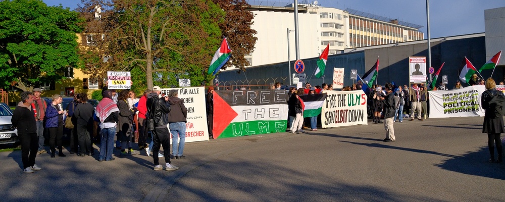 Aktivist*innen stehen am Rand des Kreisverkehrs vor Stuttgart-Stammheim um die Angeklagten beim Transport zu grüßen