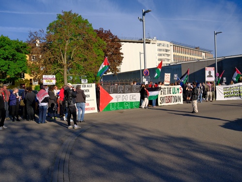 Aktivist*innen stehen am Rand des Kreisverkehrs vor Stuttgart-Stammheim um die Angeklagten beim Transport zu grüßen