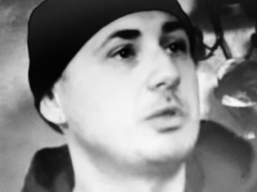 Schwarz weiß Foto von Gino, auf dem er eine dunkle Mütze trägt